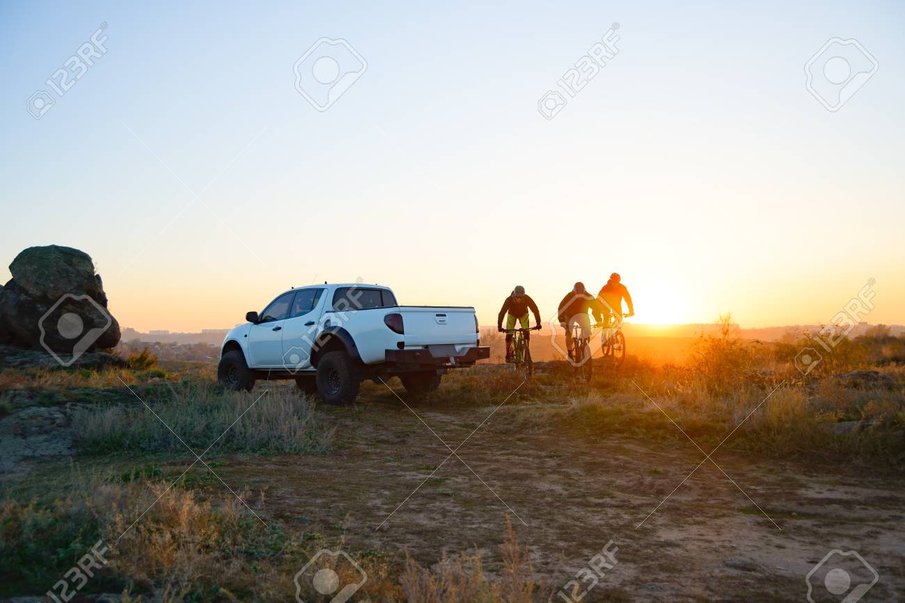 http://outdoorshuttle.com/wp-content/uploads/2020/02/114924582-friends-riding-bikes-in-the-mountains-in-front-of-the-pickup-off-road-truck-at-sunset-adventure-and-.jpg